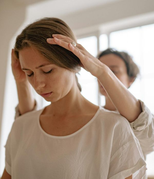 Woman in a tranquil state performing a gentle neck stretch, conveying a sense of relief.
